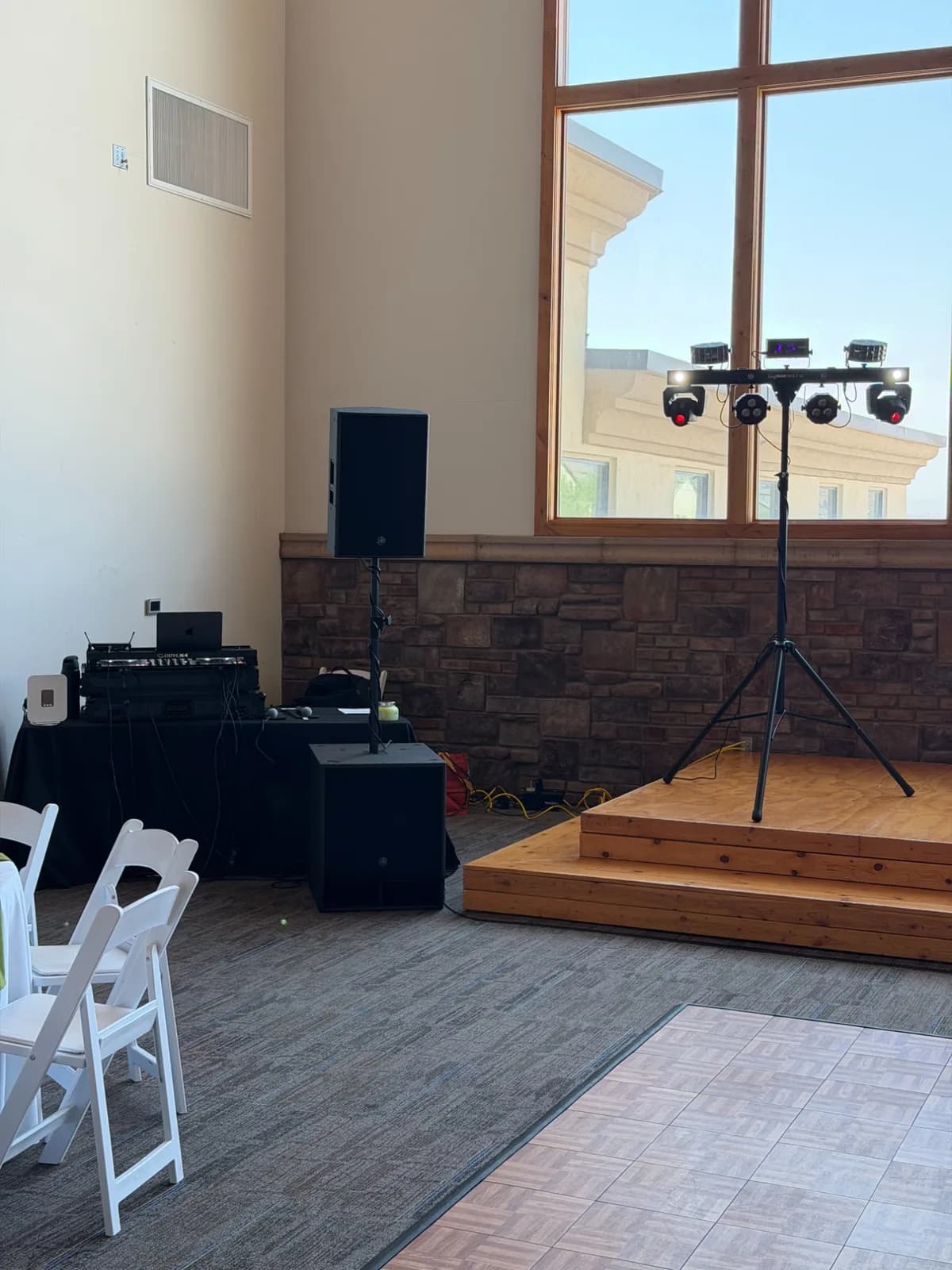 Yamaha PA speaker on a sub beside the DJ booth and lighting stand